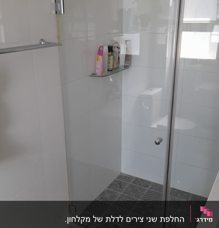 מקלחון זכוכית עם מדף בקבוקים על קיר לבן